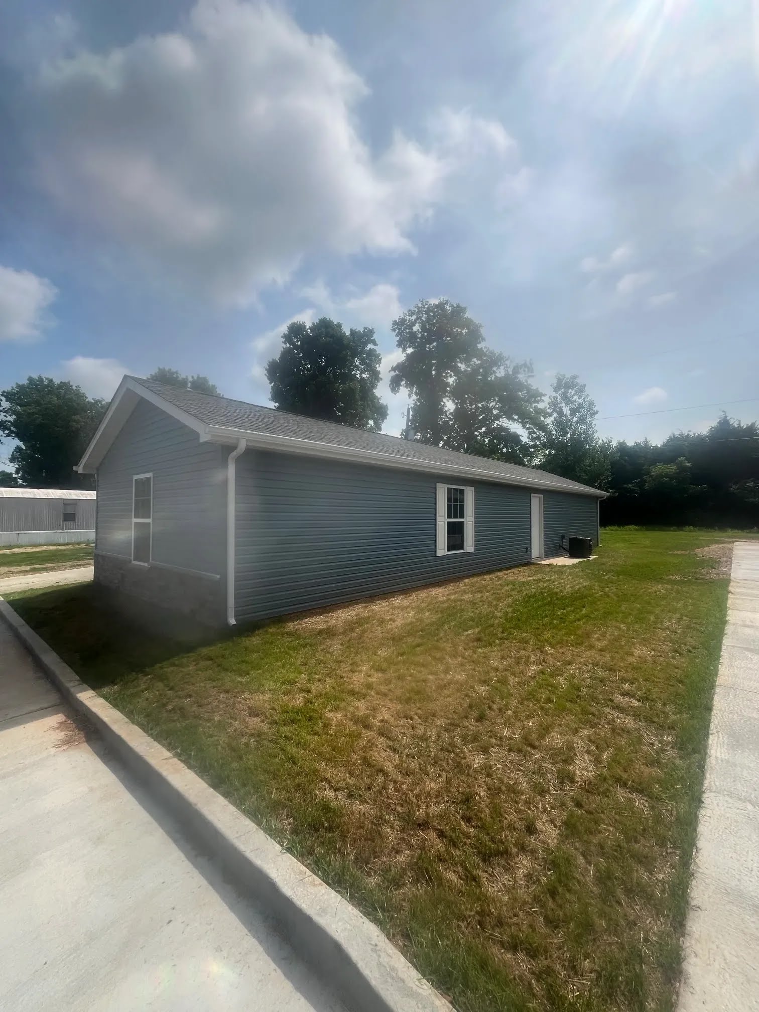 Long side of a finished home showing siding, windows, fascia, and seamless gutter