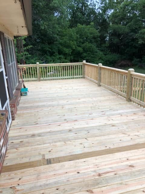 Expansive wooden deck overlooking a wooded backyard