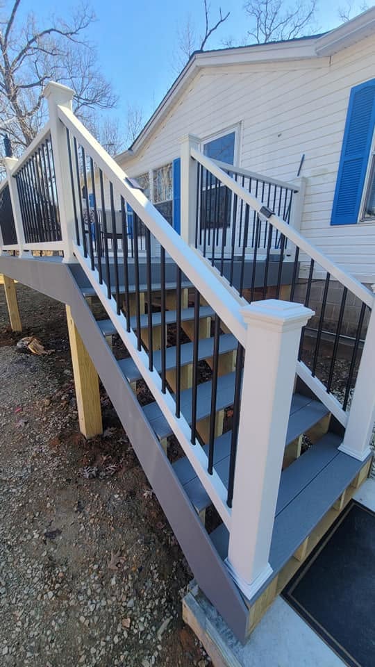 Modern deck stairs with white posts and black metal balusters